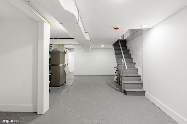 finished below grade area featuring baseboards and stairway