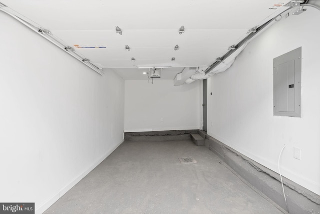 garage featuring baseboards, a garage door opener, and electric panel