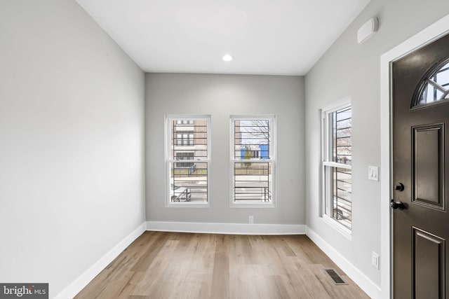 foyer entrance with baseboards, visible vents, and light wood-style flooring