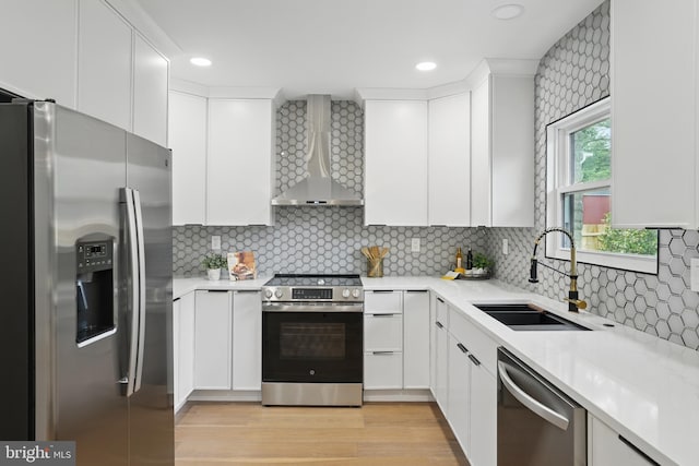 7434 Mason Ln, Falls Church, VA 22042 - kitchen featuring stainless steel appliances, wall chimney exhaust hood, a sink, light countertops, and white cabinets