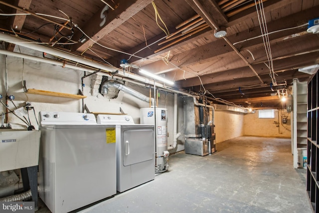 below grade area with heating unit, water heater, and separate washer and dryer