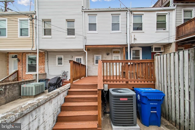 back of property with fence and central AC