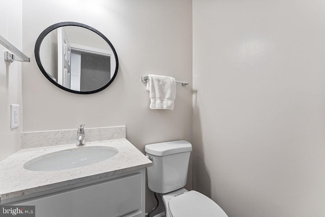 half bathroom featuring toilet and vanity
