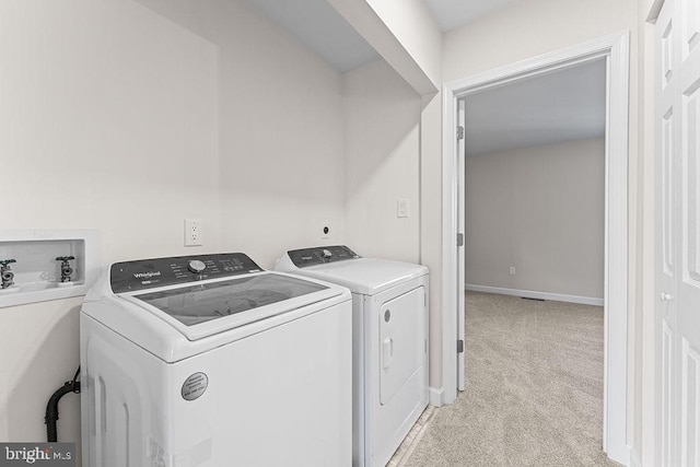 laundry area featuring laundry area, washing machine and dryer, baseboards, and light colored carpet