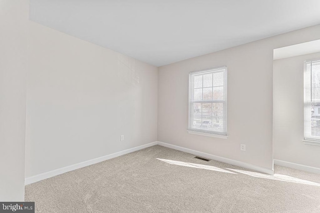 carpeted empty room with baseboards and visible vents