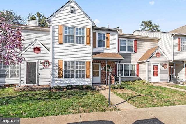 townhome / multi-family property with a front yard