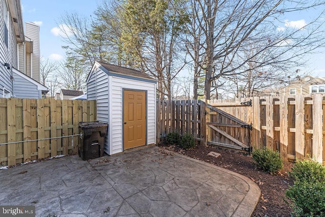 view of shed featuring a fenced backyard and a gate