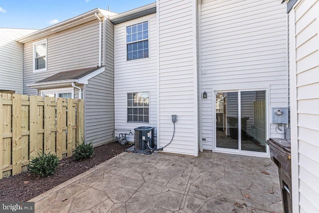 back of property with central air condition unit, a patio area, and fence