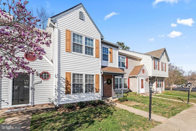 townhome / multi-family property with a front lawn