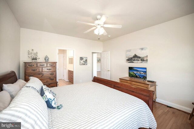 bedroom featuring baseboards, ceiling fan, light wood-style flooring, and connected bathroom