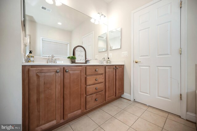 full bathroom with a sink, double vanity, visible vents, and tile patterned floors