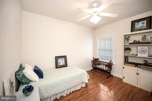 bedroom featuring baseboards, dark wood-style floors, and a ceiling fan