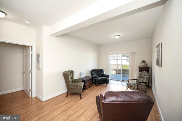 sitting room with baseboards and light wood-style flooring