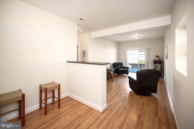 sitting room with baseboards, visible vents, and light wood-style floors