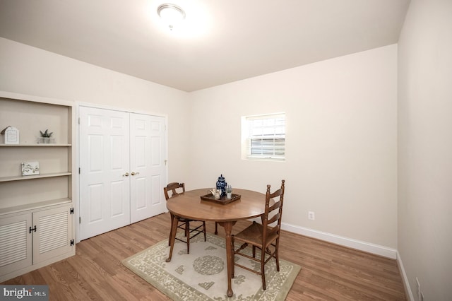 dining space with baseboards and light wood-type flooring