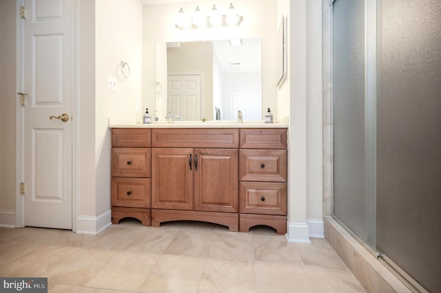 full bathroom featuring a shower with shower door and vanity