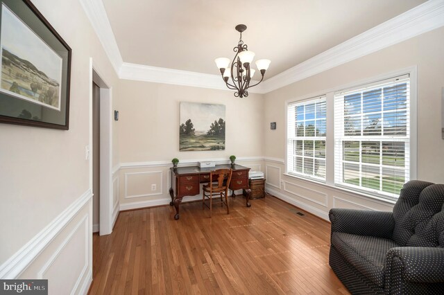 office featuring a decorative wall, a chandelier, crown molding, and light wood finished floors