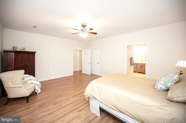 bedroom with baseboards, connected bathroom, light wood finished floors, visible vents, and a ceiling fan