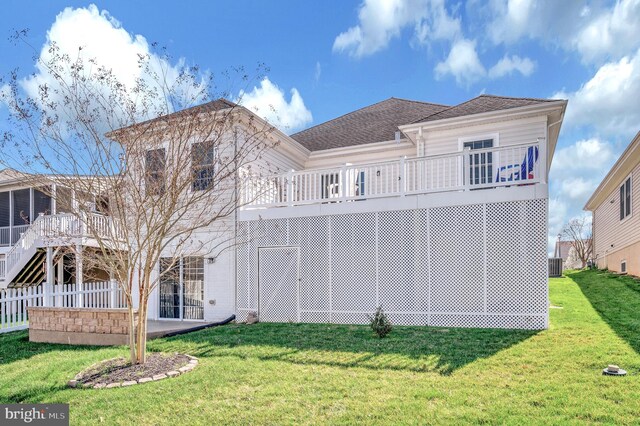 rear view of property featuring roof with shingles, fence, a patio area, and a lawn