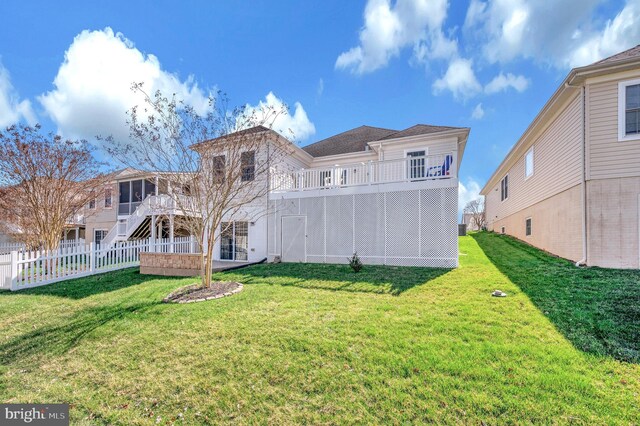 rear view of house featuring a yard, a deck, fence, and stairs