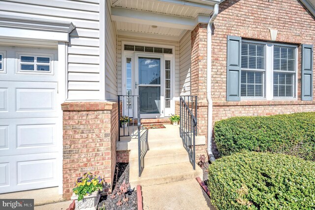 doorway to property with brick siding and an attached garage