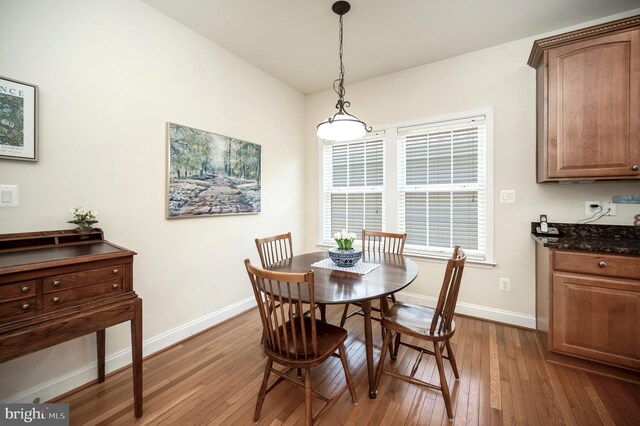 dining area featuring baseboards and hardwood / wood-style flooring