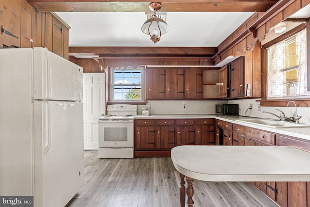 kitchen featuring light countertops, light wood-style floors, a sink, and white appliances
