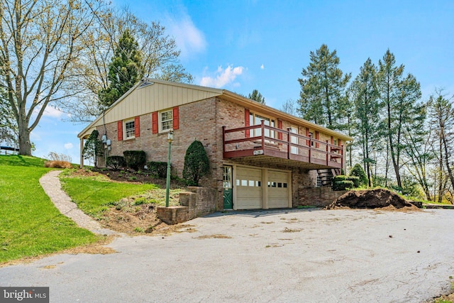 view of side of home featuring an attached garage, driveway, and brick siding