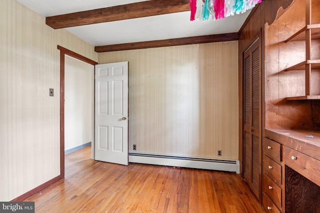 unfurnished bedroom with hardwood / wood-style floors, a baseboard heating unit, a closet, beam ceiling, and baseboards