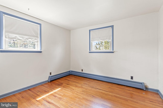 spare room featuring light wood-style floors, baseboards, and baseboard heating