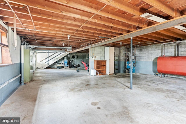 below grade area featuring a heating unit, stairs, and heating fuel