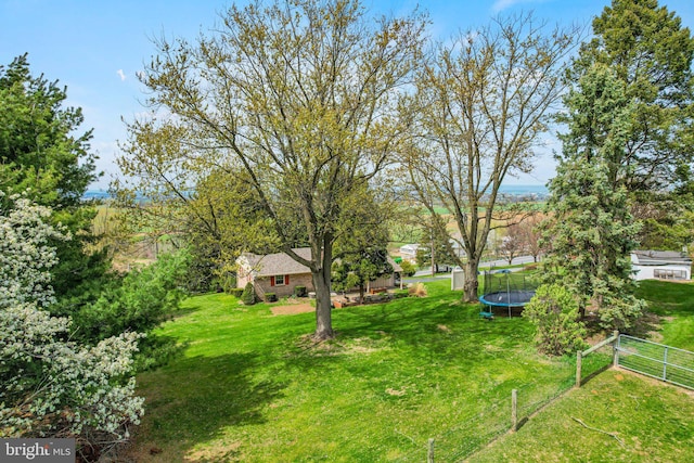 view of yard featuring fence and a trampoline