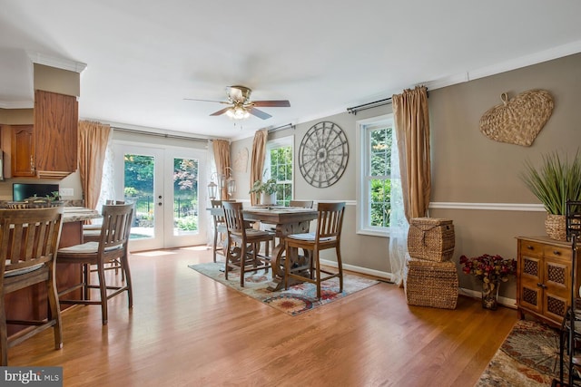 dining area featuring baseboards, light wood finished floors, french doors, and ceiling fan