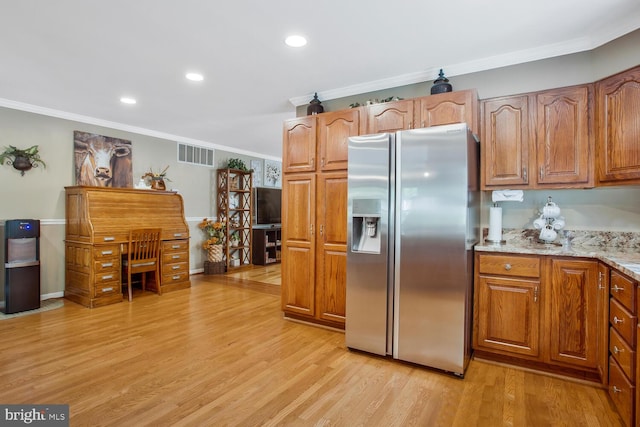 kitchen featuring brown cabinetry, stainless steel fridge with ice dispenser, visible vents, light wood-style floors, and ornamental molding