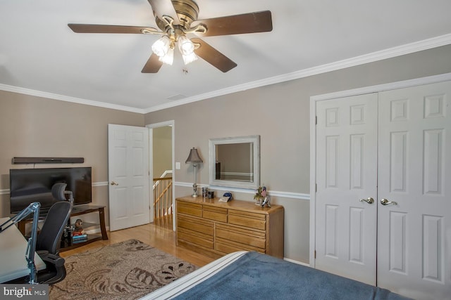 bedroom featuring ceiling fan, a closet, wood finished floors, and ornamental molding