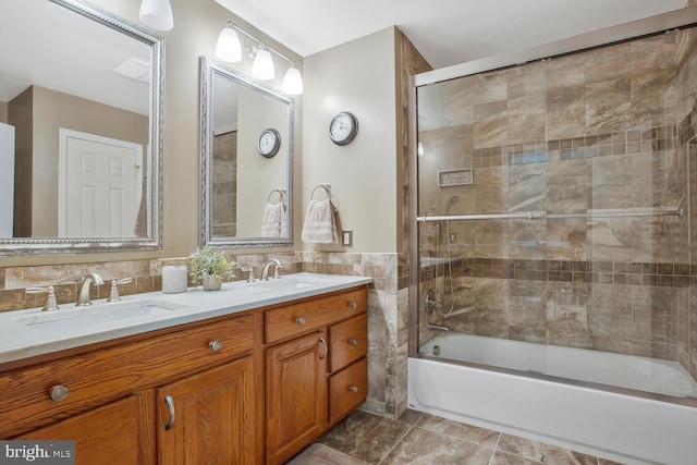 full bathroom with a sink, double vanity, tile walls, and shower / bath combination with glass door