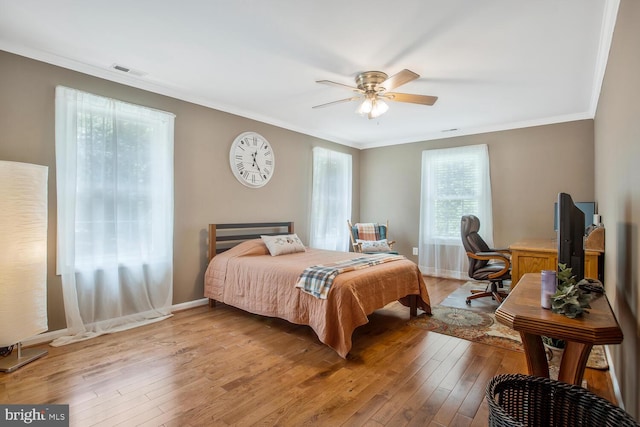 bedroom with baseboards, ornamental molding, visible vents, and light wood-style floors
