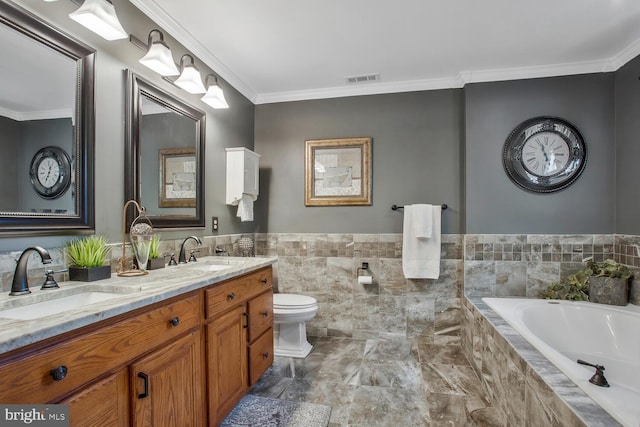 bathroom featuring tiled bath, visible vents, crown molding, and a sink