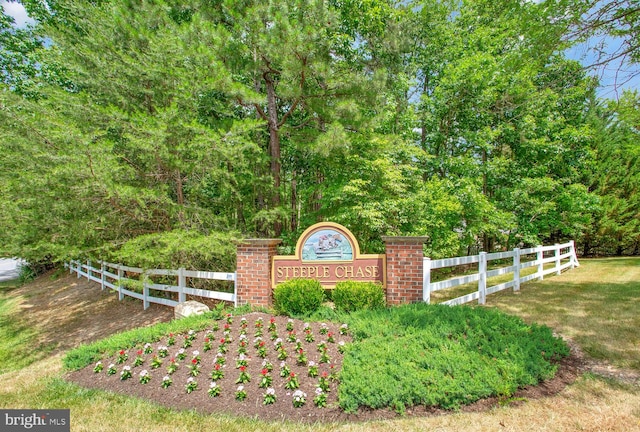 community / neighborhood sign featuring fence