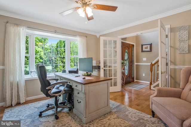 office space with baseboards, light wood-type flooring, crown molding, and plenty of natural light