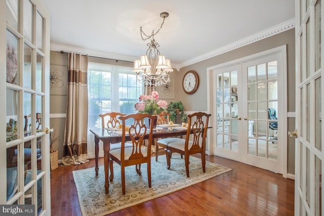 dining room featuring a chandelier, ornamental molding, french doors, and wood finished floors