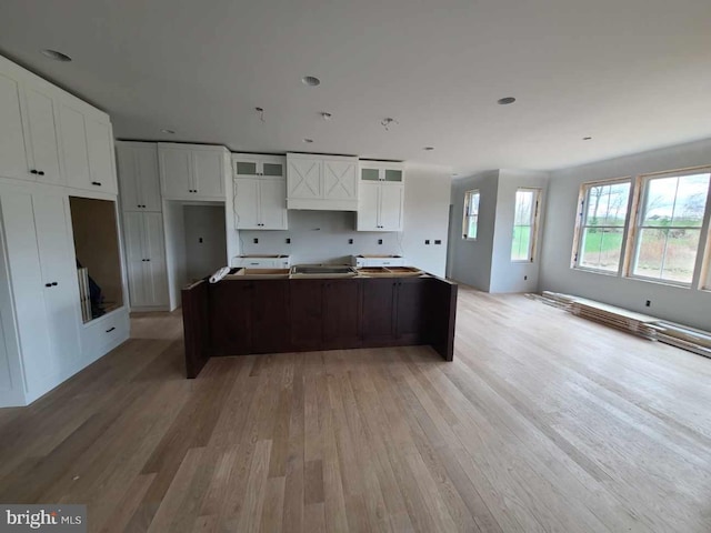 124 Primrose Ct, State College, PA 16801 - kitchen featuring glass insert cabinets, white cabinets, a kitchen island, custom exhaust hood, and light wood finished floors