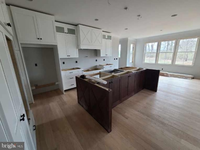 124 Primrose Ct, State College, PA 16801 - kitchen with white cabinetry, glass insert cabinets, a center island, and light wood-type flooring