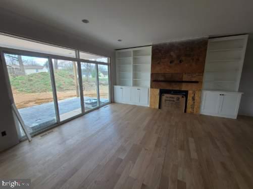 124 Primrose Ct, State College, PA 16801 - unfurnished living room featuring plenty of natural light, a large fireplace, and wood finished floors