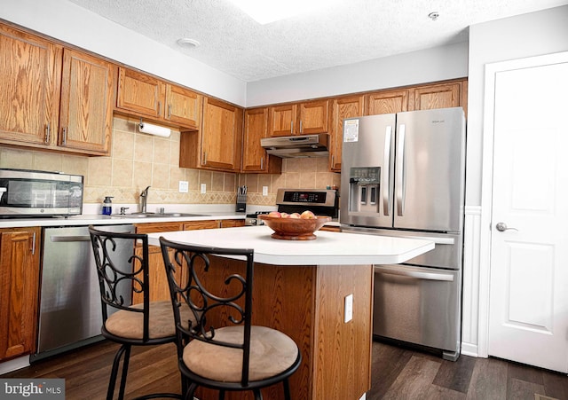 518 Macintosh Cir, Joppa, MD 21085 - kitchen featuring a sink, stainless steel appliances, light countertops, under cabinet range hood, and brown cabinetry