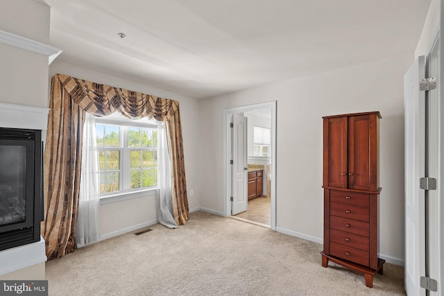 2710 Beech Orchard Ln, Upper Marlboro, MD 20774 - unfurnished bedroom featuring visible vents, light carpet, ensuite bath, baseboards, and a glass covered fireplace