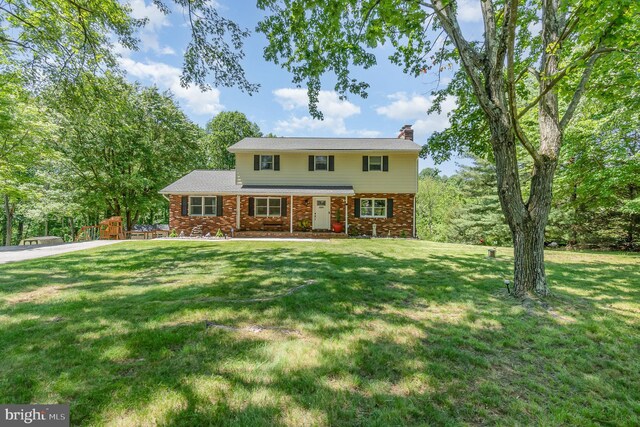 2220 Timothy Dr, Westminster, MD 21157 - view of front facade featuring a chimney, a front lawn, and brick siding