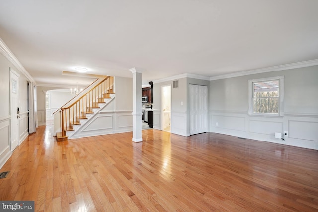 2220 Timothy Dr, Westminster, MD 21157 - unfurnished living room with decorative columns, light wood-style floors, and stairs