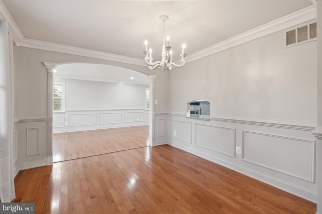 2220 Timothy Dr, Westminster, MD 21157 - unfurnished dining area with ornate columns, an inviting chandelier, arched walkways, hardwood / wood-style flooring, and visible vents