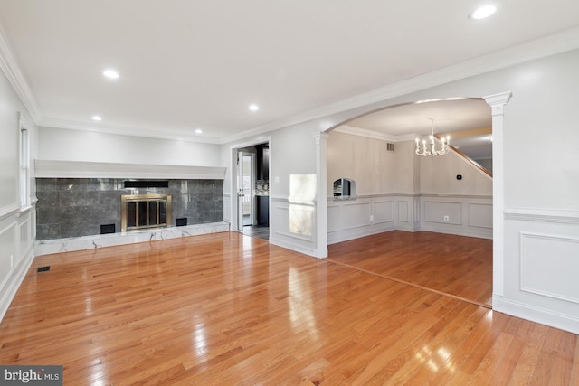 2220 Timothy Dr, Westminster, MD 21157 - unfurnished living room with decorative columns, wood finished floors, a high end fireplace, arched walkways, and an inviting chandelier